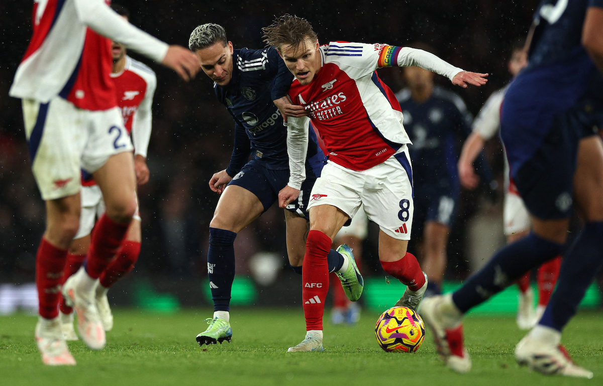 Martin Odegaard protege el balón ante la presión de Antony, jugador de Manchester United. (Adrian DENNIS/AFP)