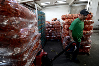 Un trabajador transporta zanahorias en un mercado de Guadalajara, México.
