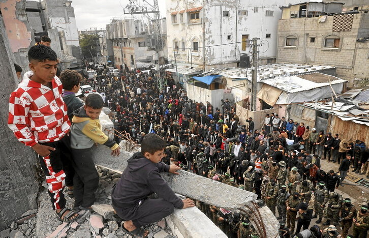 Niños palestinos observan a combatientes de Hamas en el funeral de uno de sus comandantes, Marwan Issa, muerto en marzo de 2024.