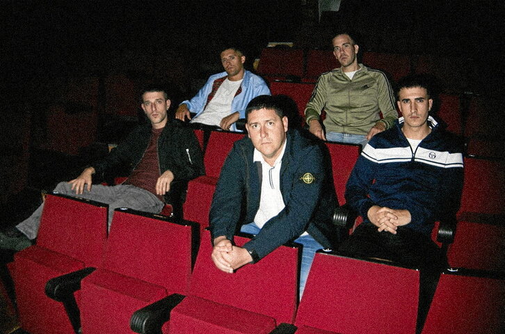 Taldeko kideak ageri diren bi argazkiotan eskuinean dagoena da Manex Egaña bateria-jotzailea.