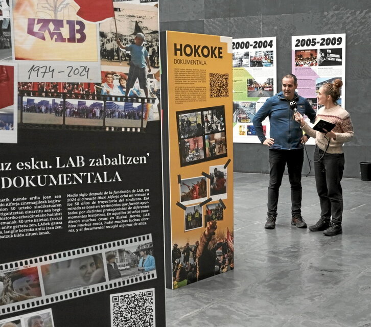 Asier Azpilikueta (LAB) con Maite Bidarte (NAIZ Irratia), en la muestra del Parlamento.