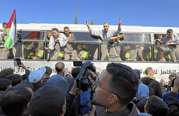 En la página anterior, presos palestinos llegan a Jan Yunis, en Gaza, el 1 de febrero. Arriba, los ataúdes con los cuerpos de cuatro muertos en Gaza tras ser capturados en los ataques del 7 de octubre de 2023.