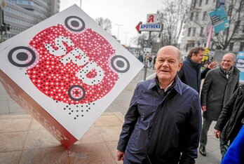 El canciller en funciones, Olaf Scholz, camina junto a un cubo del SPD colocado frente a la sede del partido en Berlín.