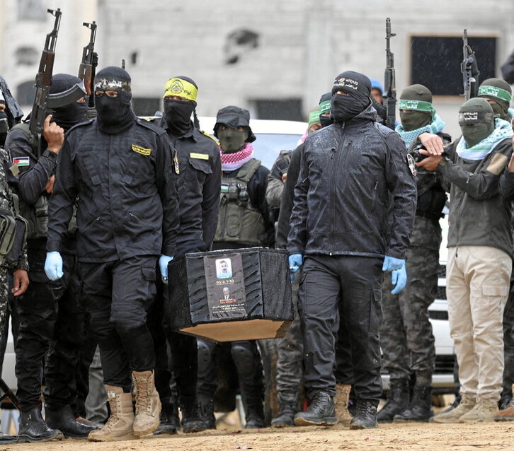 Combatientes palestinos llevan uno de los ataúdes  a la Cruz Roja el jueves.