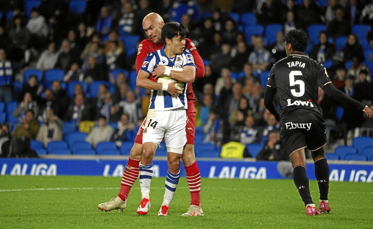 El portero del Leganés Dmitrovic sostiene con los brazos a Kubo en un lance del partido.