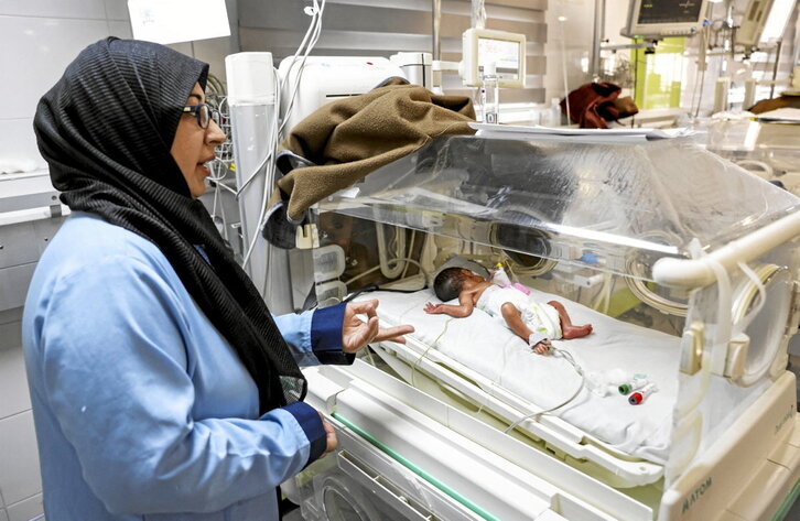 Una trabajadora sanitaria observa un bebé prematuro en el hospital Nasser de Gaza.