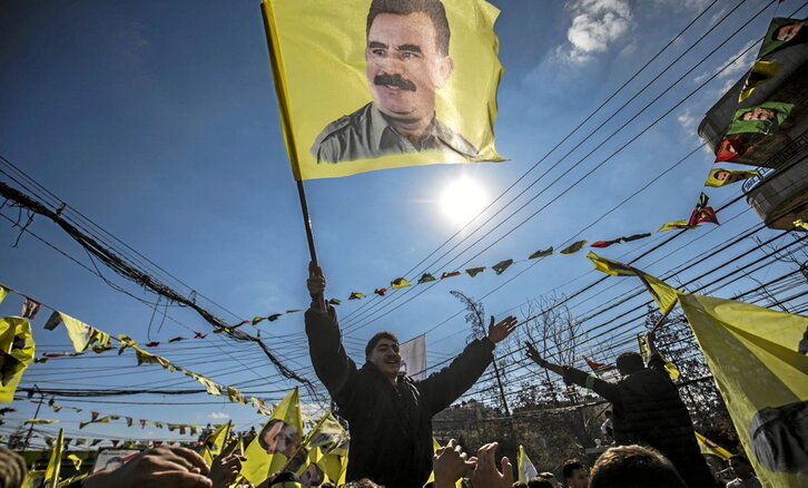 Un kurdo ondea una bandera con la imagen de Öcalan en Qamishlo, Rojava, en la lectura del llamamiento.