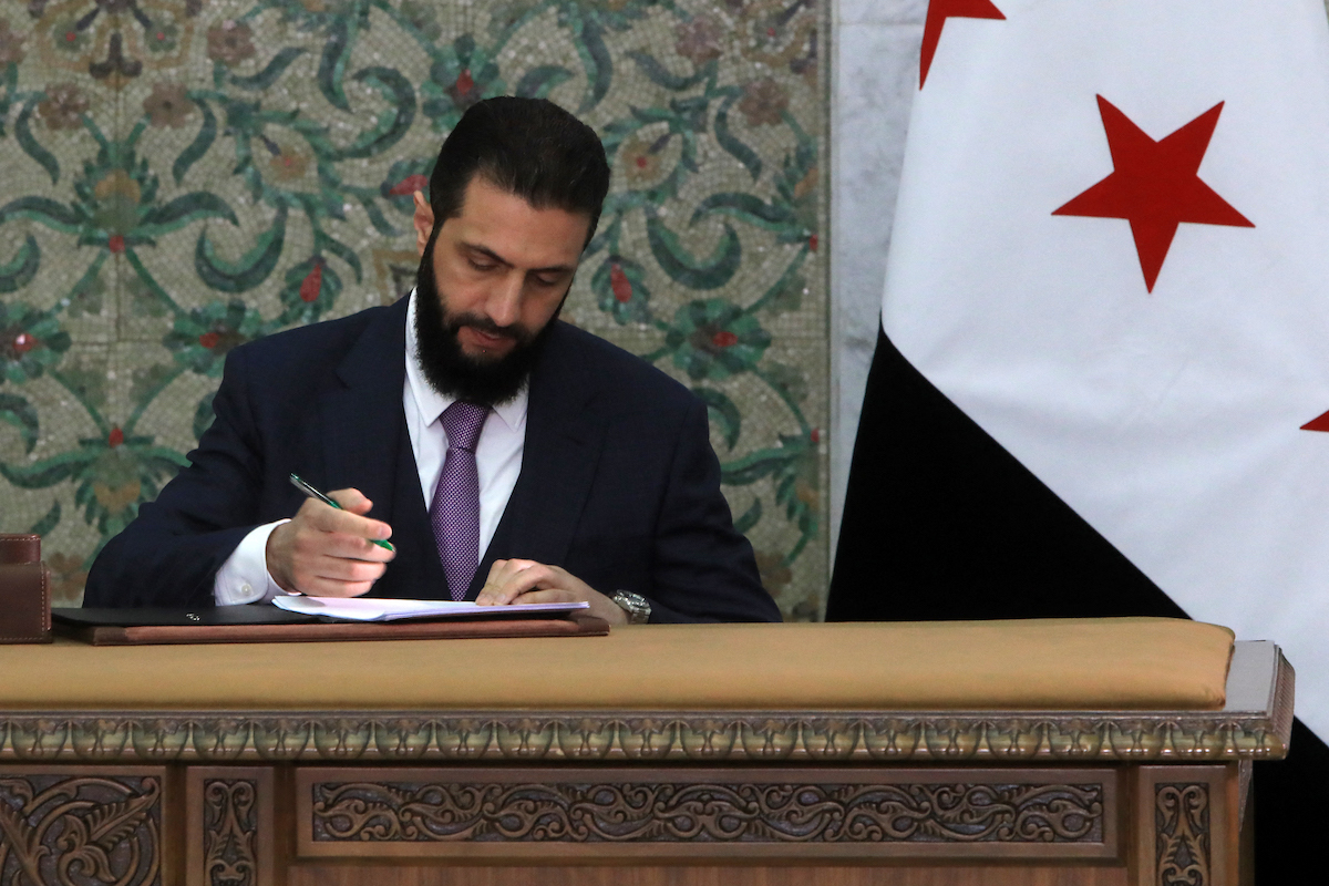 El presidente interino sirio, Ahmad Al Sharaa, firma la declaración constitucional. (Bakr ALKASEM / AFP)