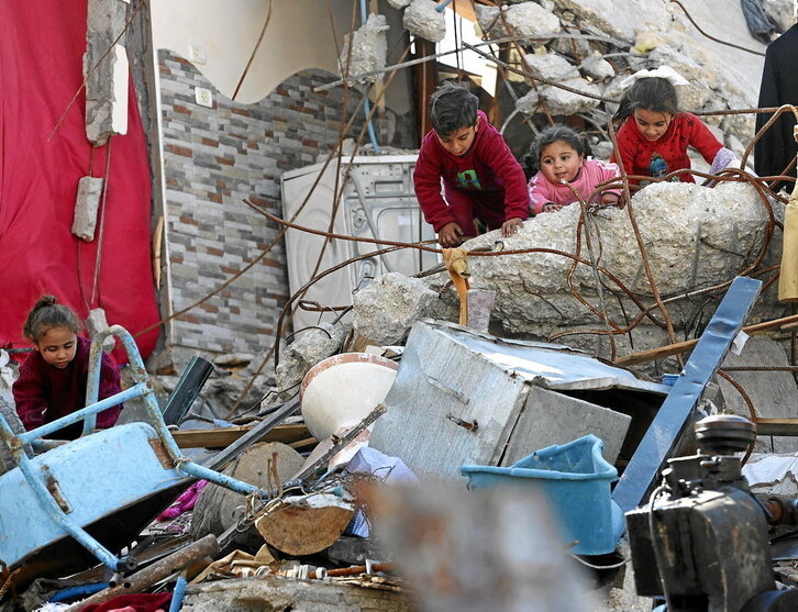 Haur batzuk, Jabalian, Gazako iparraldean, suntsitutako eraikin baten hondakinen artean jolasten.