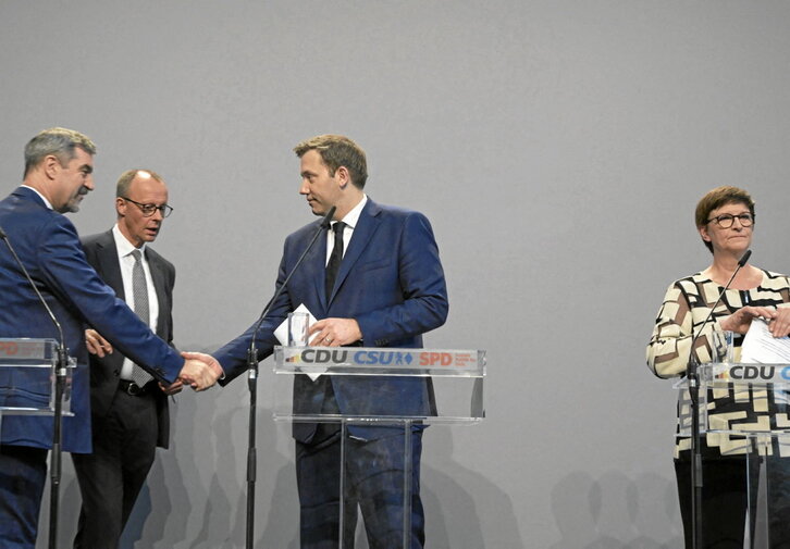 Markus Söder (CSU), Friedrich Merz (CDU) y Lars Klingbeil (SPD) se saludan en presencia de Saskia Esken, copresidenta del SPD.
