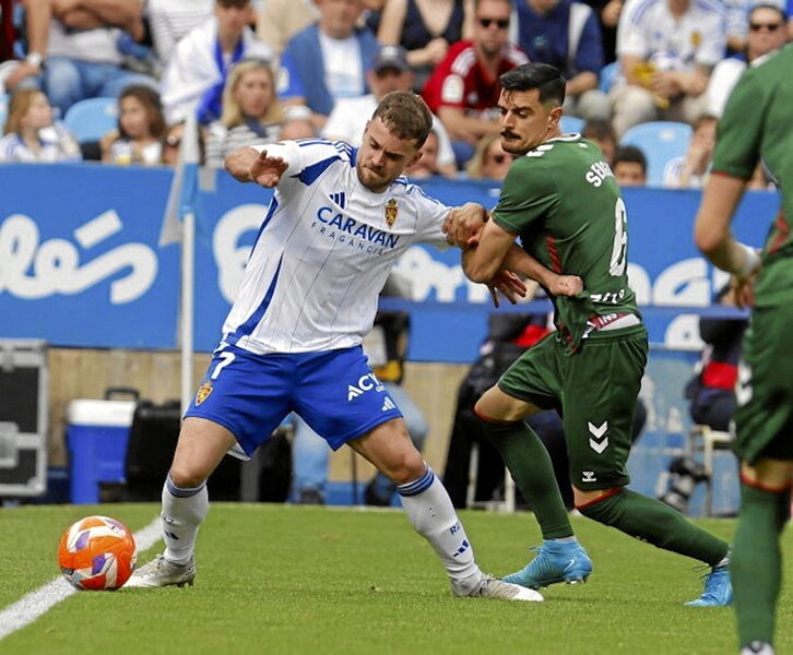Sergio intenta evitar que Soberón controle el balón.
