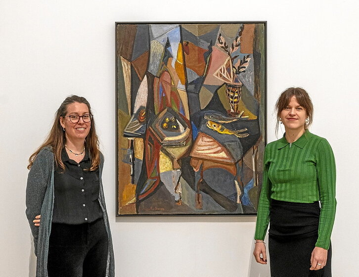 Las dos comisarias de la exposición «María Paz Jiménez, desvelar el misterio» -a la izquierda Haizea Barcenilla y a la derecha Ane Lekuona-, junto a uno de los bodegones de la pintora donostiarra.