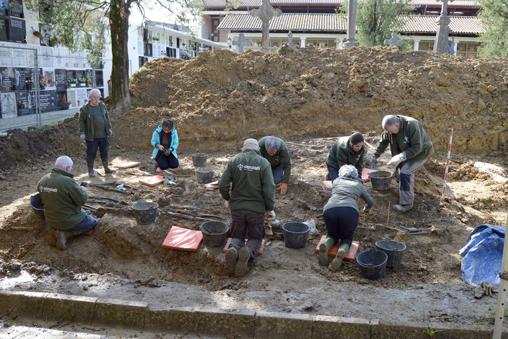 Voluntarias y voluntarios se afanan en recuperar los cuerpos de combatientes y mujeres en la fosa de Zornotza.