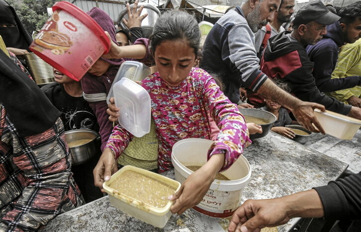 Reparto de comida caliente en el campamente de Nusairat.