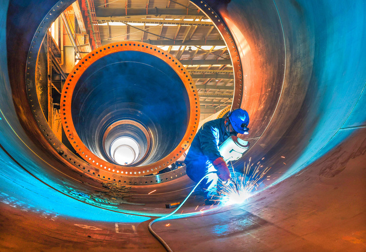 Un trabajador soldando una turbina de un molino para energía eólica, en una factoría de Lianyungang.