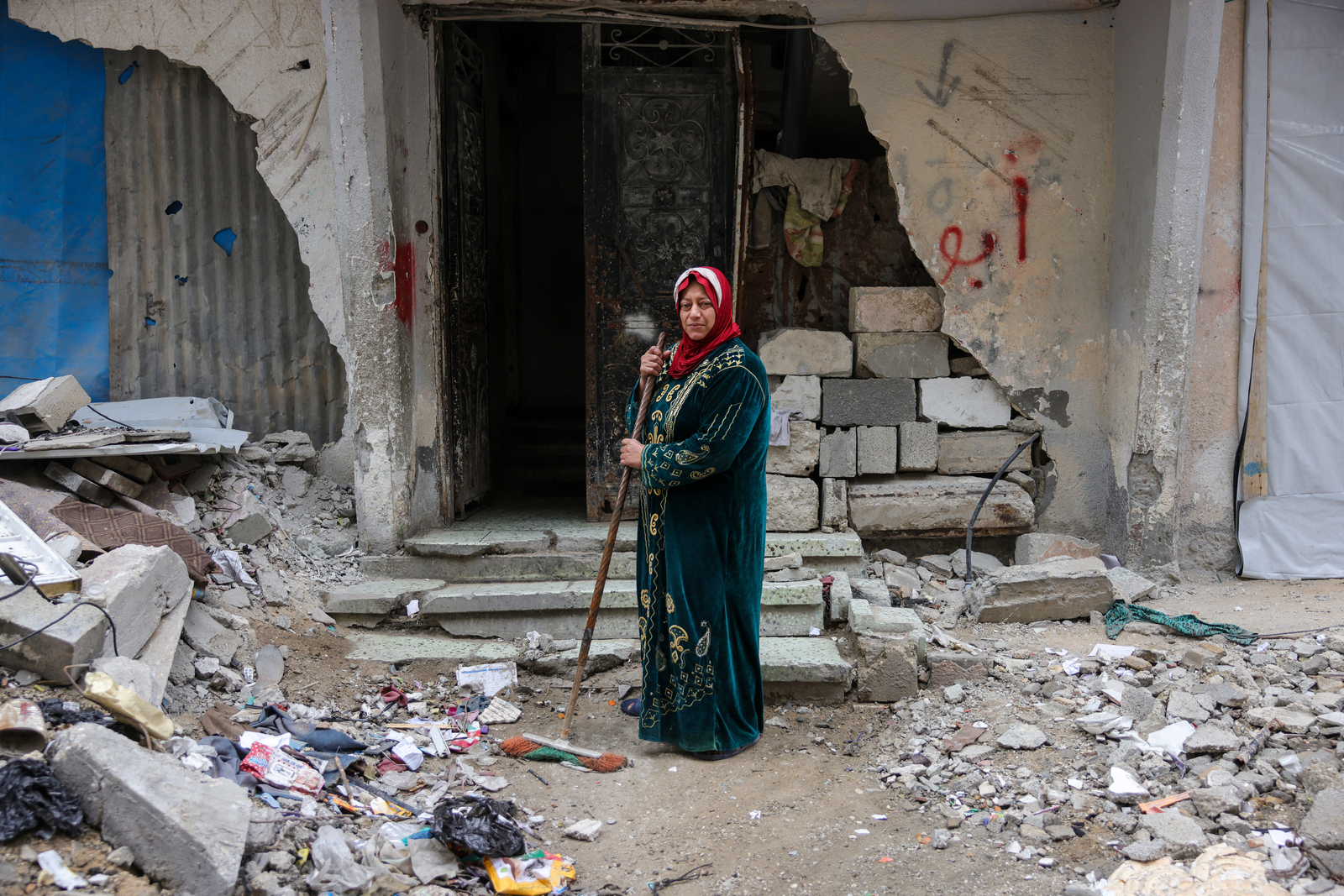Shahira Sammour, de 49 años, apila escombros a la entrada de su hogar. (Bashar Taleb / AFP)