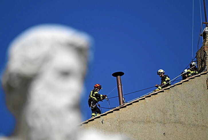 Dos operarios instalan la chimenea.
