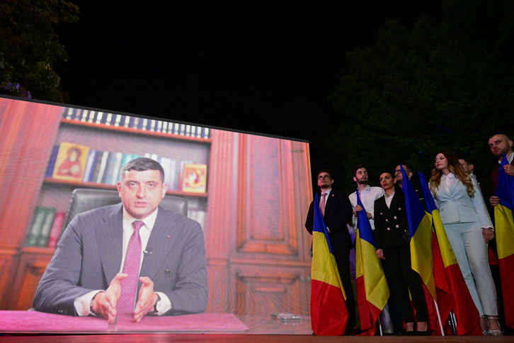 Partidarios de George Simion junto a una pantalla gigante donde se transmitió su mensaje de video.