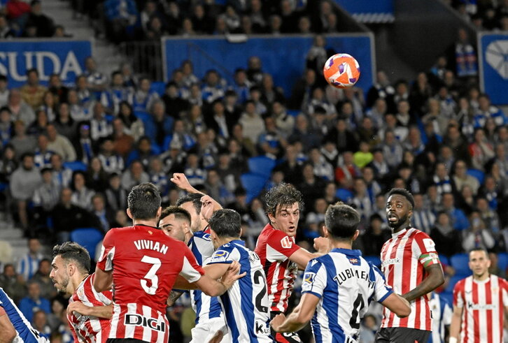Jugadores de la Real y del Athletic pugnan el balón en una acción a balón parado.