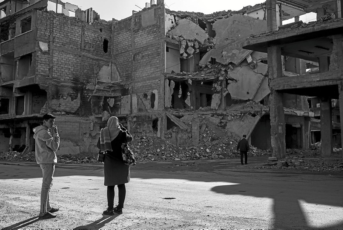Dos jóvenes esperan un taxi colectivo en la carretera principal que recorre el barrio de Yarmouk.