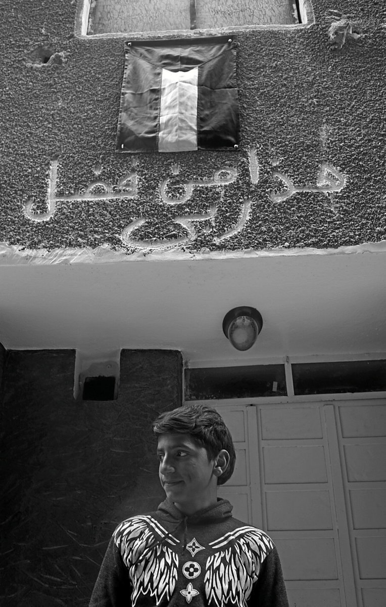 Retrato de un joven en la entrada de su casa, una de las pocas viviendas habitables en la zona.