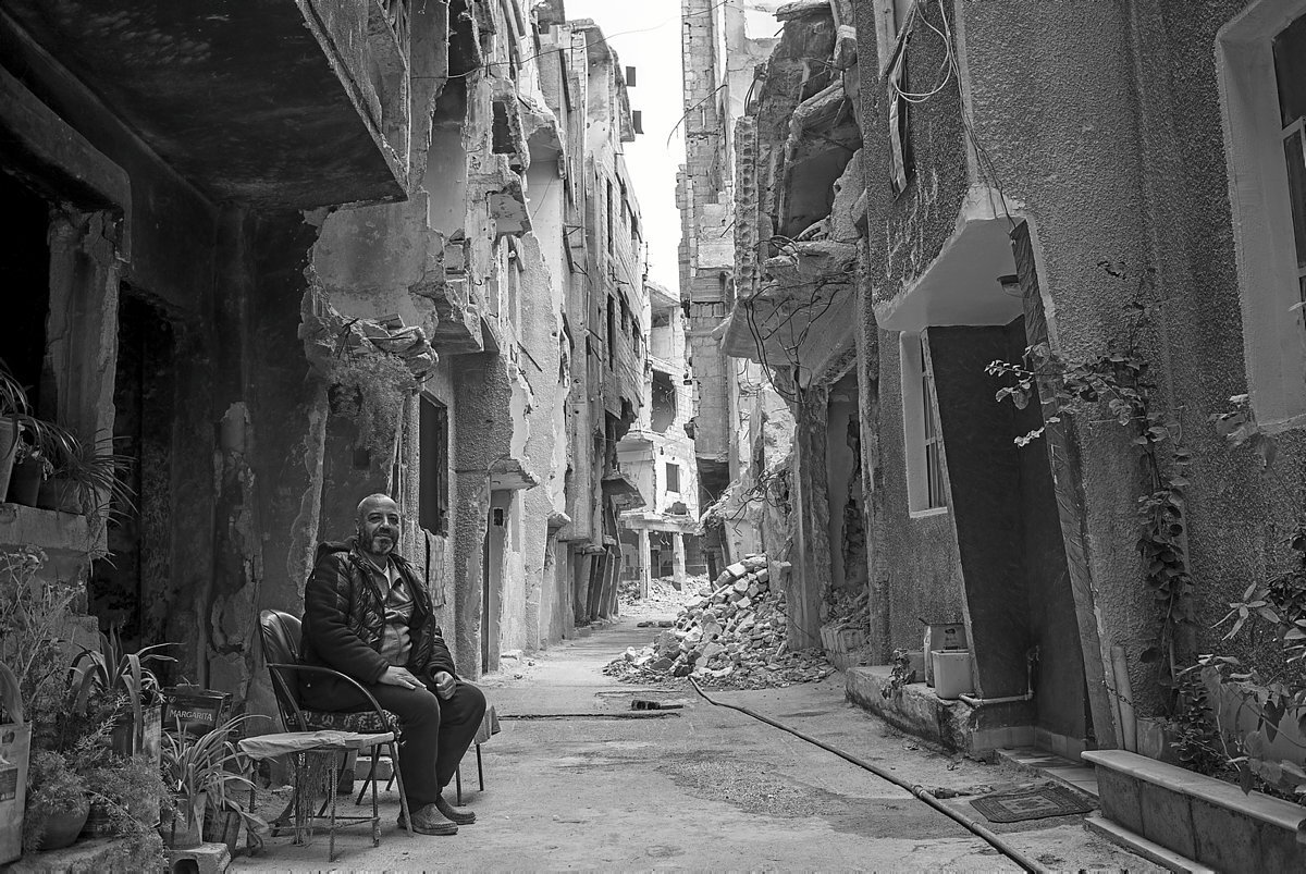 Un hombre aguarda a su amigo, recién vuelto del norte del país, para tomar té en su calle.
