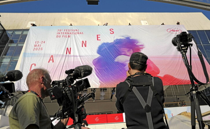 Trabajadores colocan una lona con la imagen oficial de la 78ª edición del Festival de Cine de Cannes.