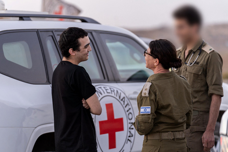 El soldado israelí-estadounidense Edan Alexander conversa con otros militares tras su liberación.