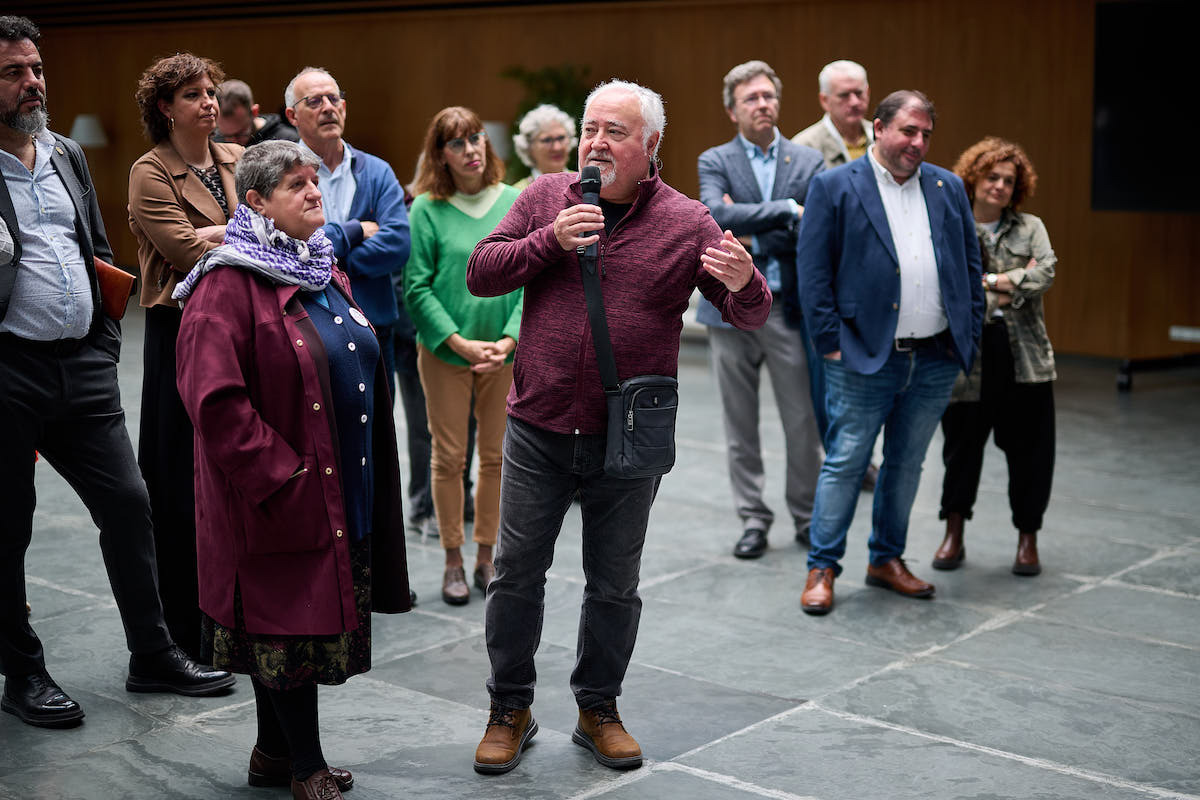 Tasio interviene en la inauguración de la muestra en el Parlamento, ante Cristina Contreras, portavoz de la Plataforma. (NAFARROAKO PARLAMENTUA)