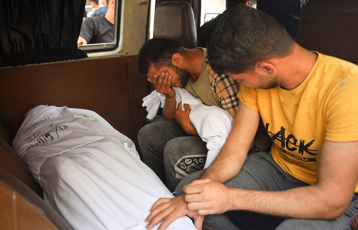 Un hombre llora ante los cuerpos de sus familiares muertos.