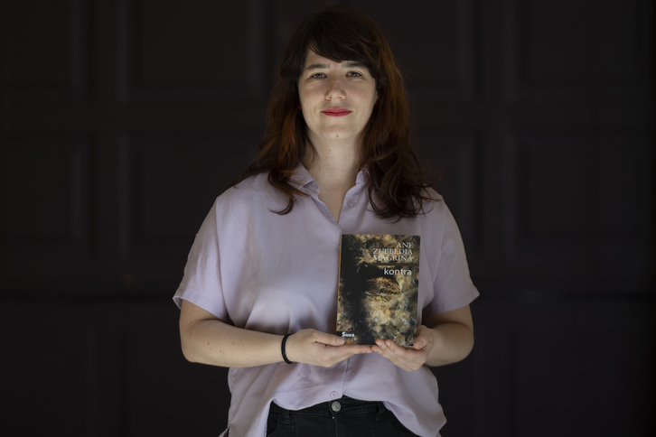 Ane Zubeldia, bere lehen poema liburua eskuetan duela.