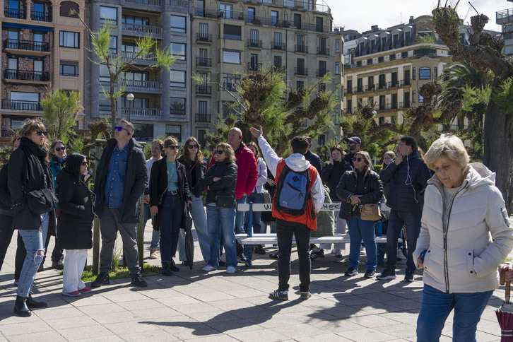 Un guía turístico con su grupo durante una visita por la zona de Alderdi Eder.