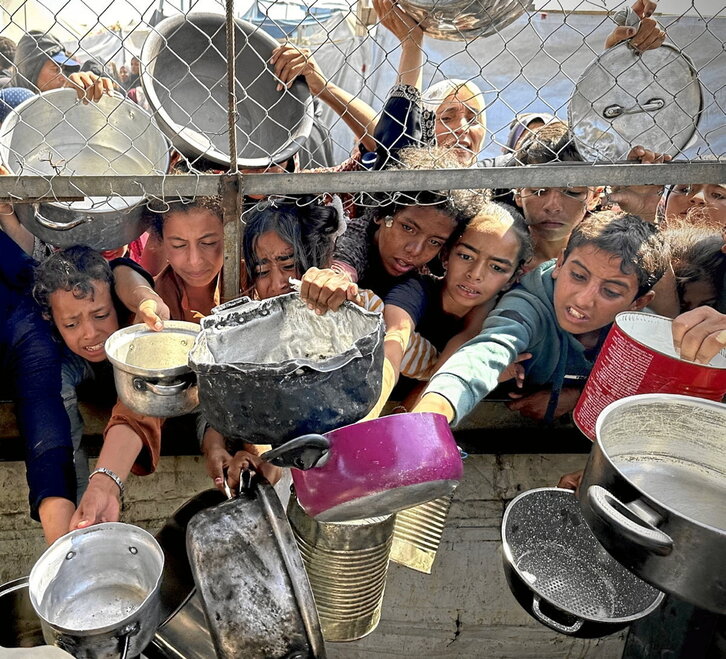 Menores gazatíes aguardan desesperados para recibir algo de comida.