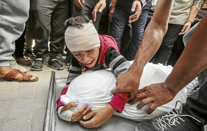 Un niño se abraza al cuerpo de un familiar cubierto por un sudario en el hospital Al Shifa, en ciudad de Gaza.