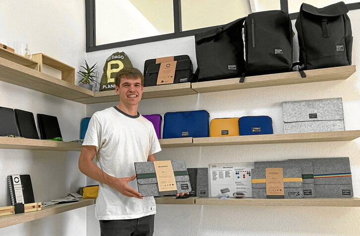 El joven emprendedor Aritz Gartzia Segurola muestra algunas de las fundas de ordenador, carpetas y mochilas que elabora Ekomodo a partir de botellas recicladas.