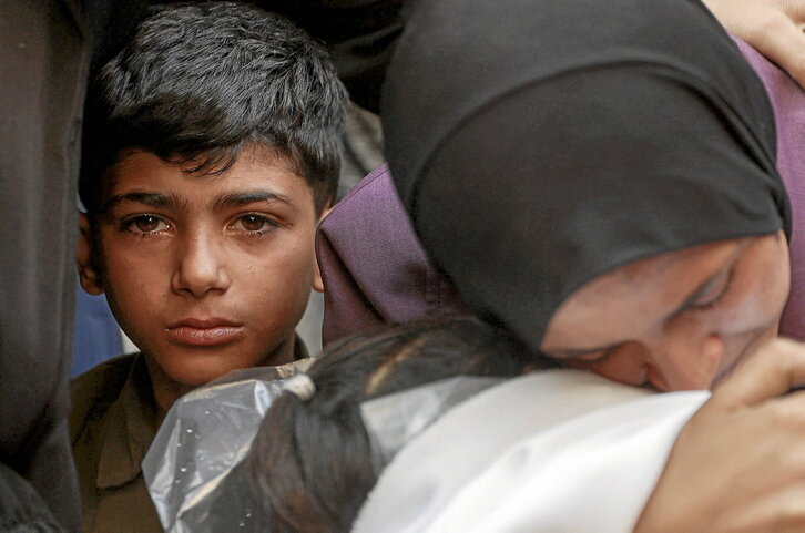 Una madre abraza el cuerpo de su hijo, muerto en los bombardeos de la noche del martes.