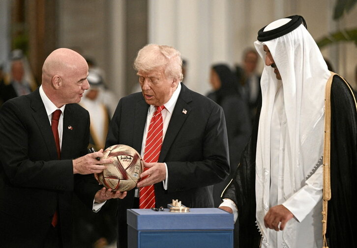 El presidente de la FIFA, Gianni Infantino,  entrega un balón al presidente de EEUU, Donald Trump, mientras el emir de Qatar, Tamim bin Hamad al-Thani (der.), observa durante una ceremonia de firma.