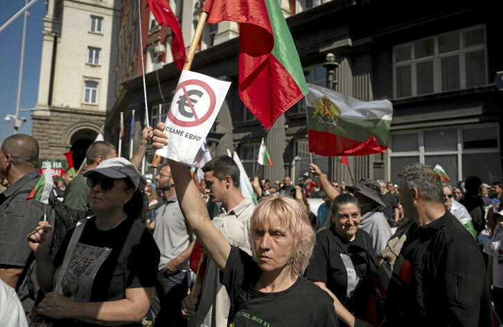 Emakume batek euroaren aurkako kartel bati eusten dio Sofian ekainaren 4an egindako manifestazio batean, Europako Batasunak Bulgaria eurogunean sartzeari argi berdea eman dion egunean.