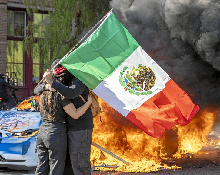 Mexikoko bandera daramaten manifestari bi Los Angelesko kaleetan besarkatzen.