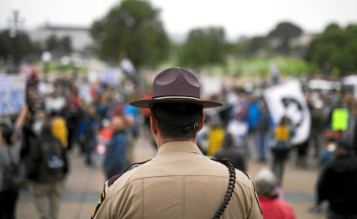 Un policía de Minnesota observa el inicio de la manifestación «No Kings» en Saint Paul, frente al Congreso del estado.