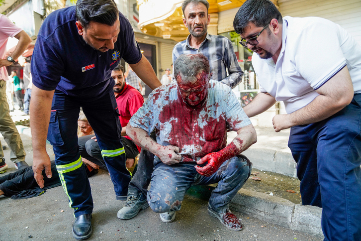 Un hombre herido por las bombas israelíes es atendido en la avenida Keshavarz de Teherán este domingo.