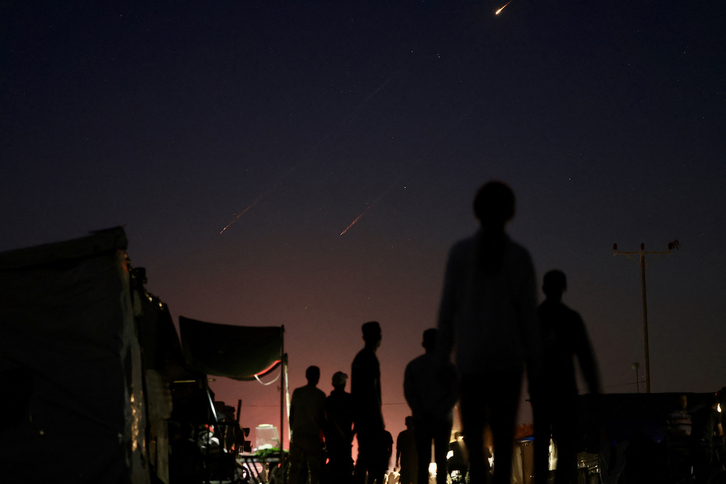 Palestinos desplazados observan las estelas de misiles iraníes que apuntan a Israel desde la zona de Mawasi, en Rafah, al sur de la Franja de Gaza.