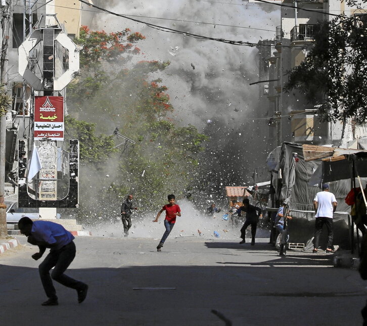 Palestinos huyen de una bomba israelí en el campo de refugiados de Bureij.