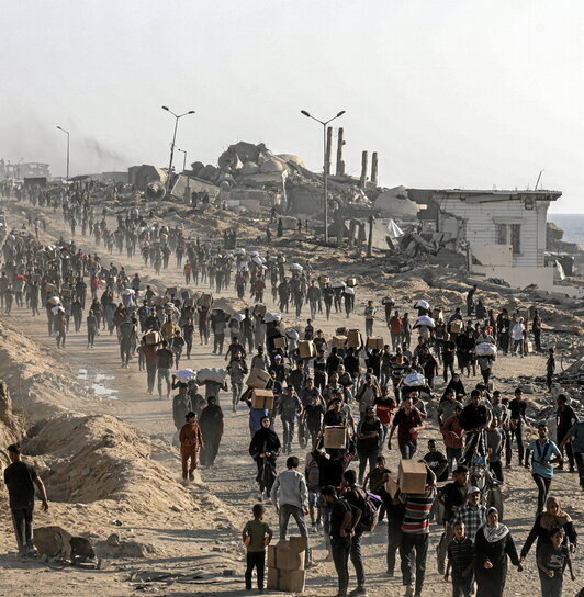Palestinos con cajas de comida, en medio de continuos ataques en Ciudad de Gaza.