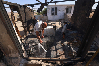Nasser Ishreiteh y su familia recogen los restos de la vivienda incendiada por colonos en Susya, cerca de Hebrón.