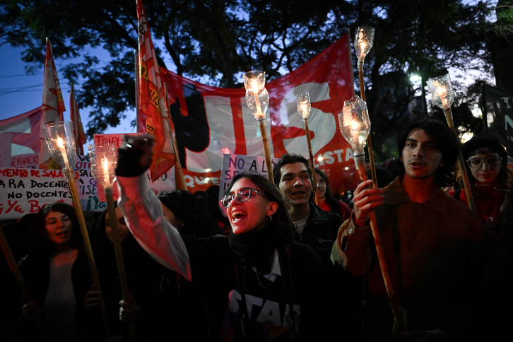 Alumnos y profesores universitarios argentinos portan antorchas en la manifestación de Buenos Aires.