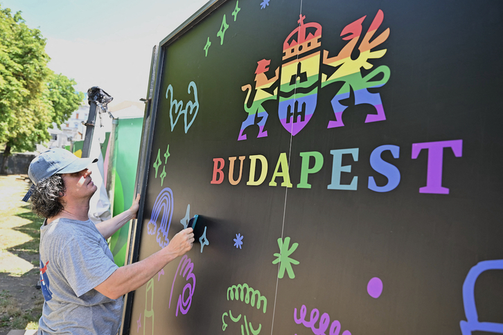 Un trabajador prepara un cartel con los colores del arcoíris con el logo del Ayuntamiento de Budapest este viernes.