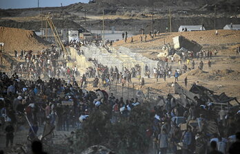 Palestinos se reúnen junto a un punto de distribución de la GHF cerca del campo de refugiados de Nuseirat.