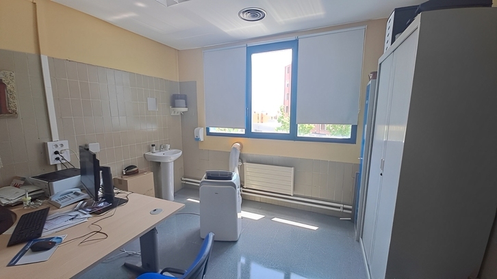 Una consulta con los estores bajados y un aparato de climatización.