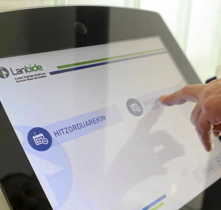 Una persona saca la papeleta con su turno para hacer gestiones en Lanbide.